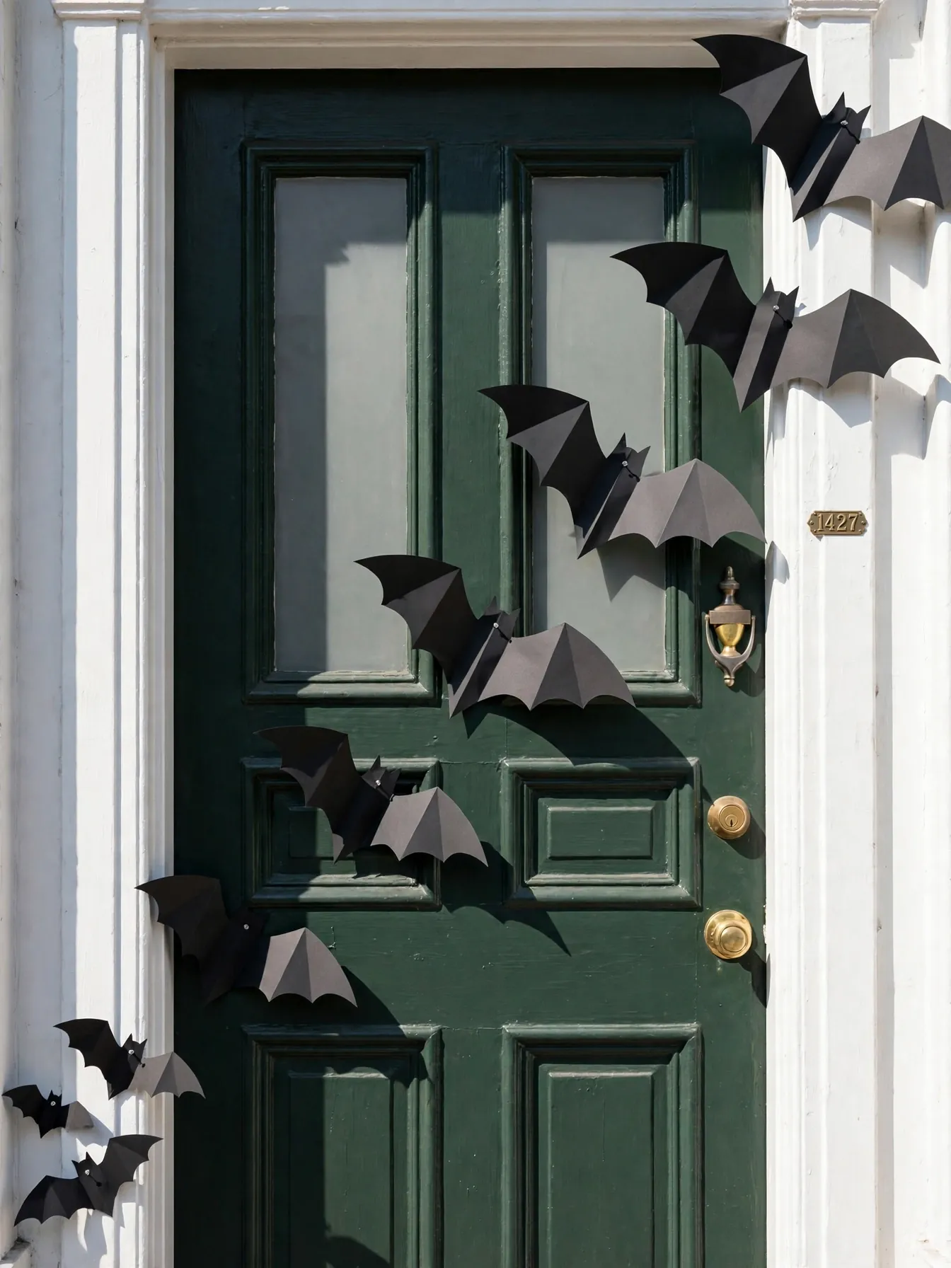 Black paper bats climbing up a front door frame for Halloween